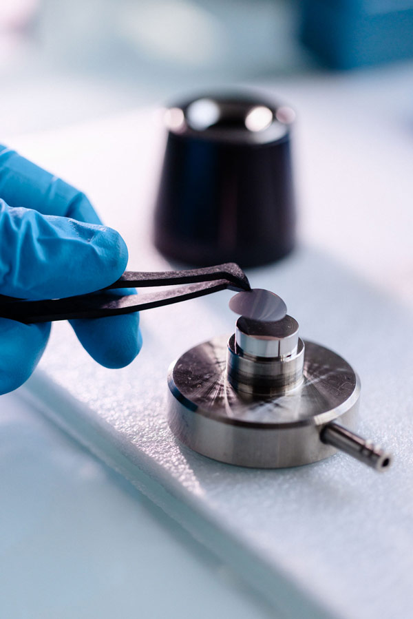A SiBoost electrode disc positioned on a crimping press to seal the cell